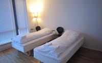 Lyst dobbeltrom på Hordatun Hotel, utstyrt med komfortable senger og moderne innreiing, perfekt for kvile etter aktivitetar i området.