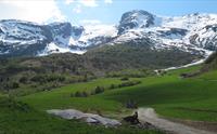 Snødekte fjell og grøne bakkar på Reisæter