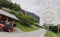 Skilt som peker mot Store Naa Siderkompani langs en landevei i Hardanger.