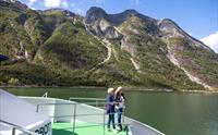 Turistar ser på fjorden frå turistbåtruta i Hardanger.