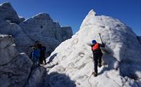 Folk går på isbre med blå himmel og guide i Hardanger
