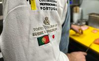 Nærbilde av kokkens uniform med Tokyo College Of Sushi & Washoku logo på UNI Sushi & Izakaya.